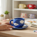 Keeyos PH Chunky Cloud Dark Blue Cup and Saucer Set with white cloud accents. Ceramic material.