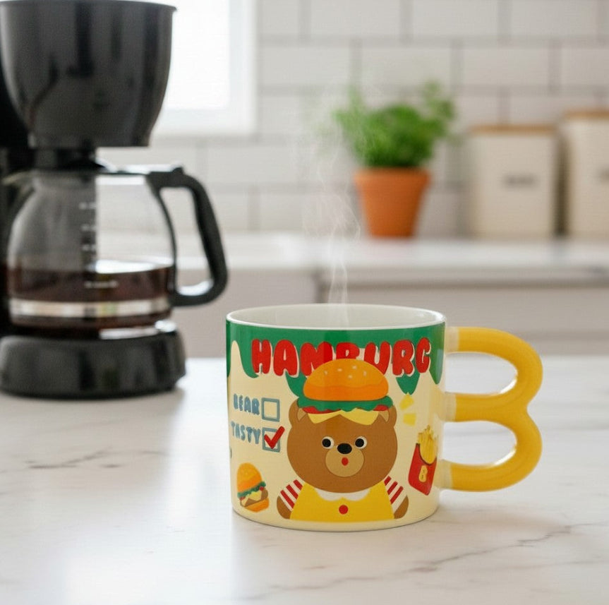 Keeyos PH yellow ceramic mug with hamburger design and bear graphic. Features a yellow loop handle.