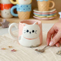 Keeyos PH Kawaii cat mug with pink exterior and white cat face design, featuring a handle.