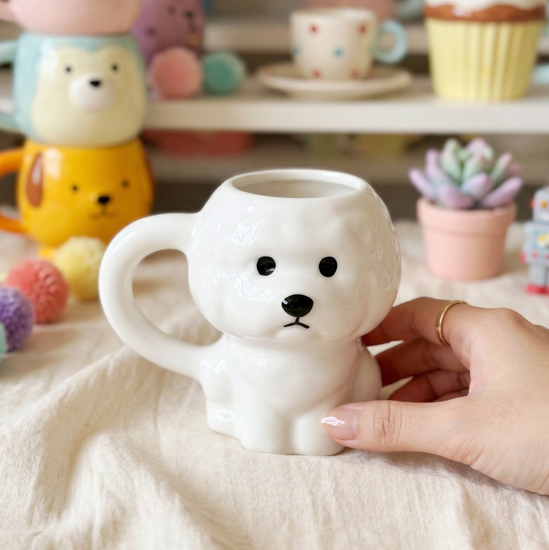 Keeyos PH white ceramic dog mug with sculpted body, front paws, and round handle. Features minimalist black eyes and nose.
